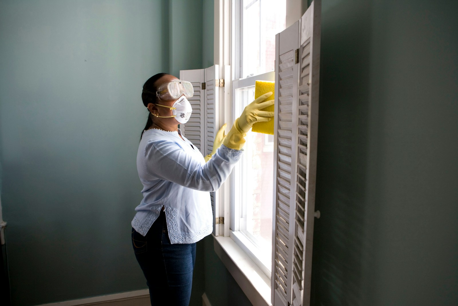 Professional cleaner sanitizing a home surface